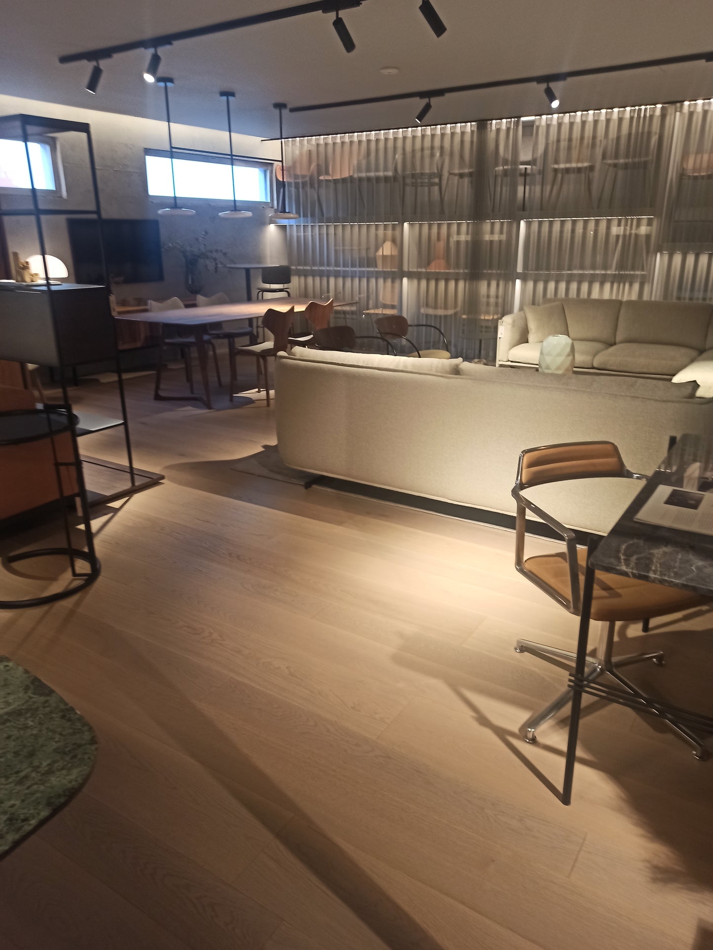 Relaxing living room with natural wood floors, a soft rug, and cozy armchairs arranged around a coffee table